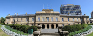 A wide-angle photo of the Tasmanian Parliament building, a grand sandstone building, on a sunny day